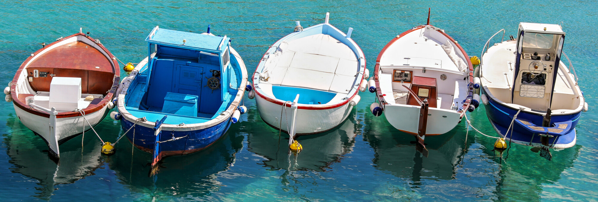 Five small fishing boats tied together in Puglia Italy.